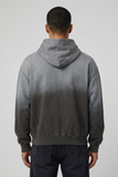 Back view of male model wearing Concept Bad Seed hoodie showing its plain washed gray-to-charcoal back